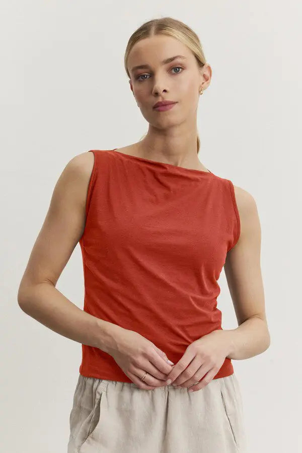 Woman wearing a red sleeveless top against a plain background