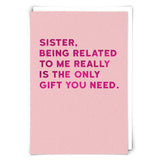 Pink card with humorous text about being related to a sister, on a white background