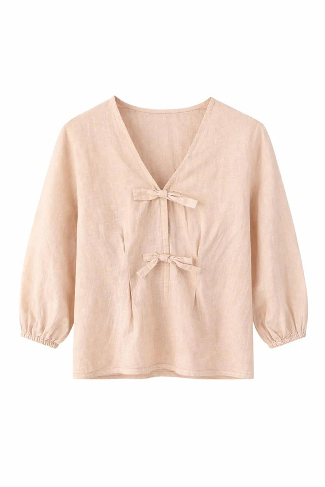 Beige blouse with bow details on a white background