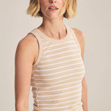 Woman wearing a beige and white striped sleeveless top against a plain background